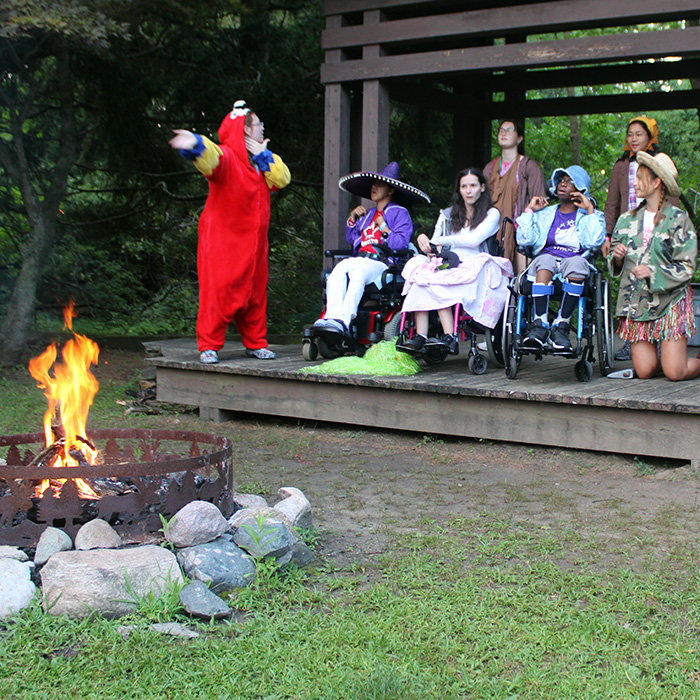 A group of campers perform a play on the outdoor stage.