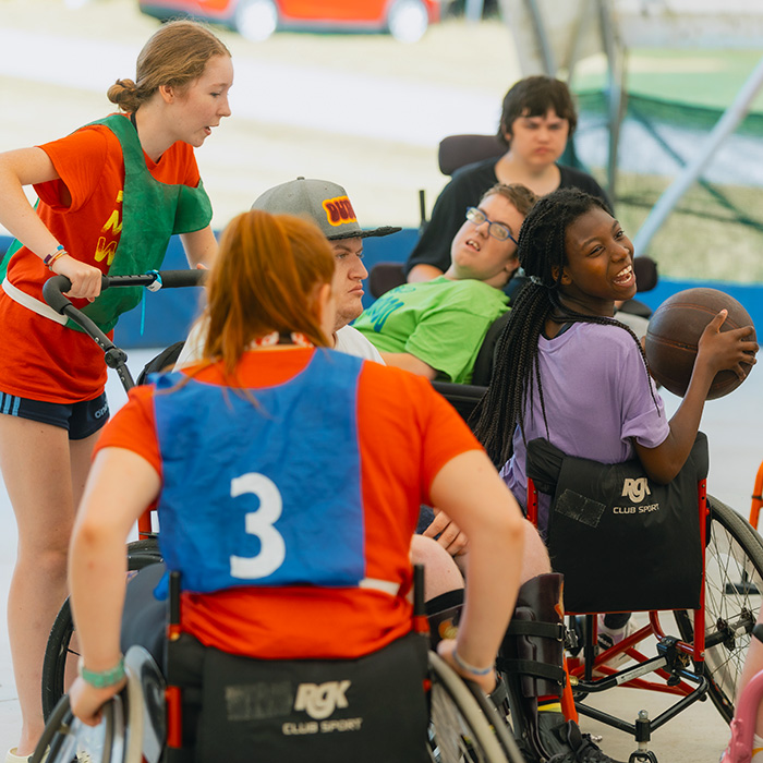 A girl smiles while playing wheelchair basketball.