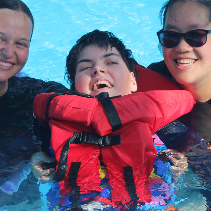 A girls smiles from the pool.